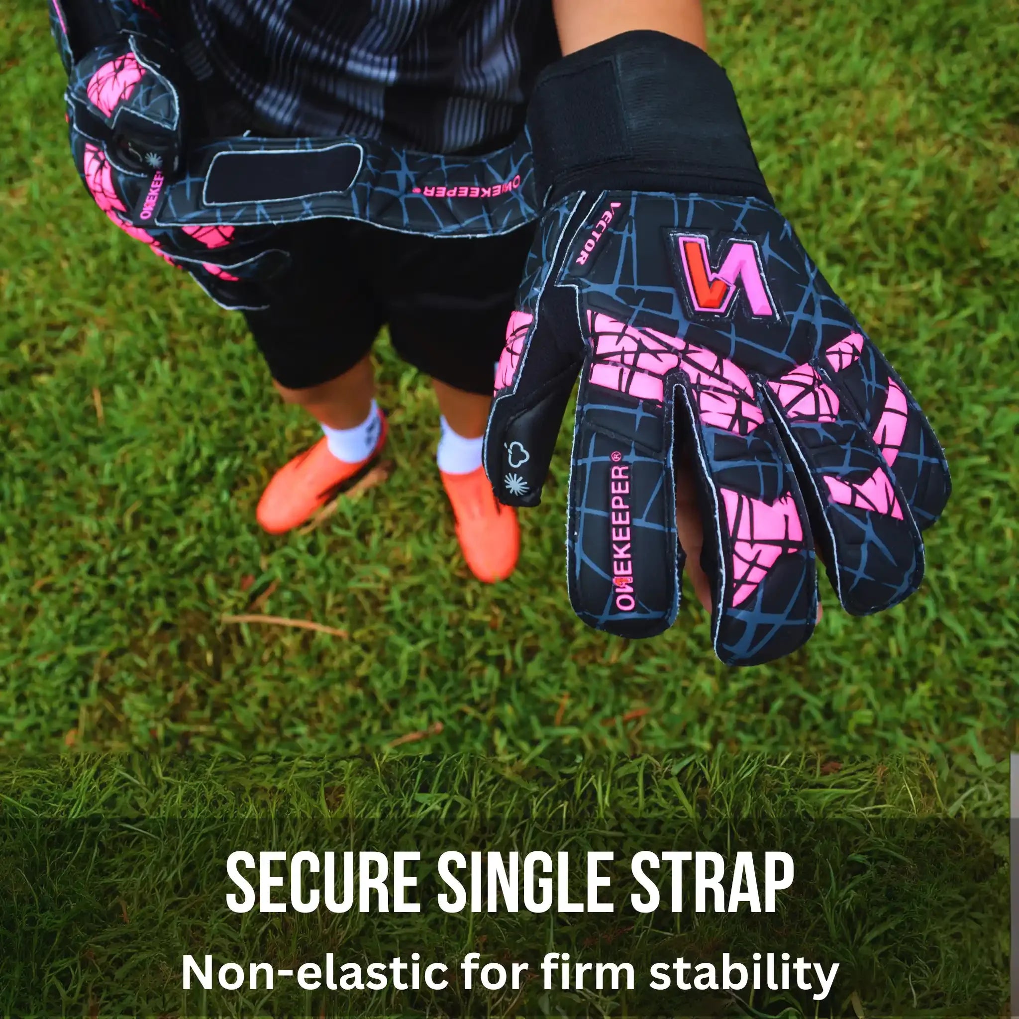 Person wearing ONEKEEPER Vector Evolution black and pink goalkeeper gloves on grass with text about a secure single strap.