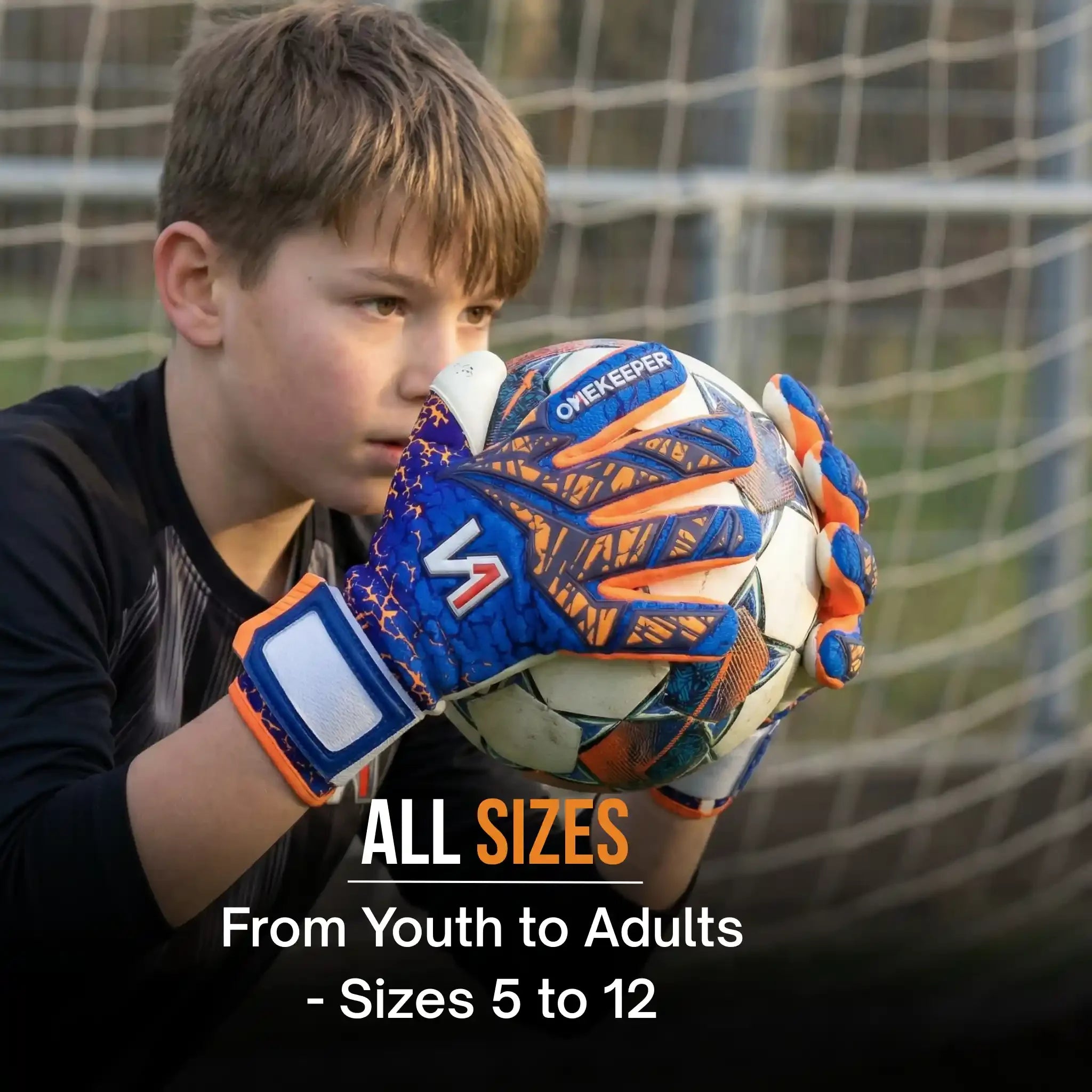 Youth soccer goalkeeper wearing blue orange gloves catching ball in front of goal net.