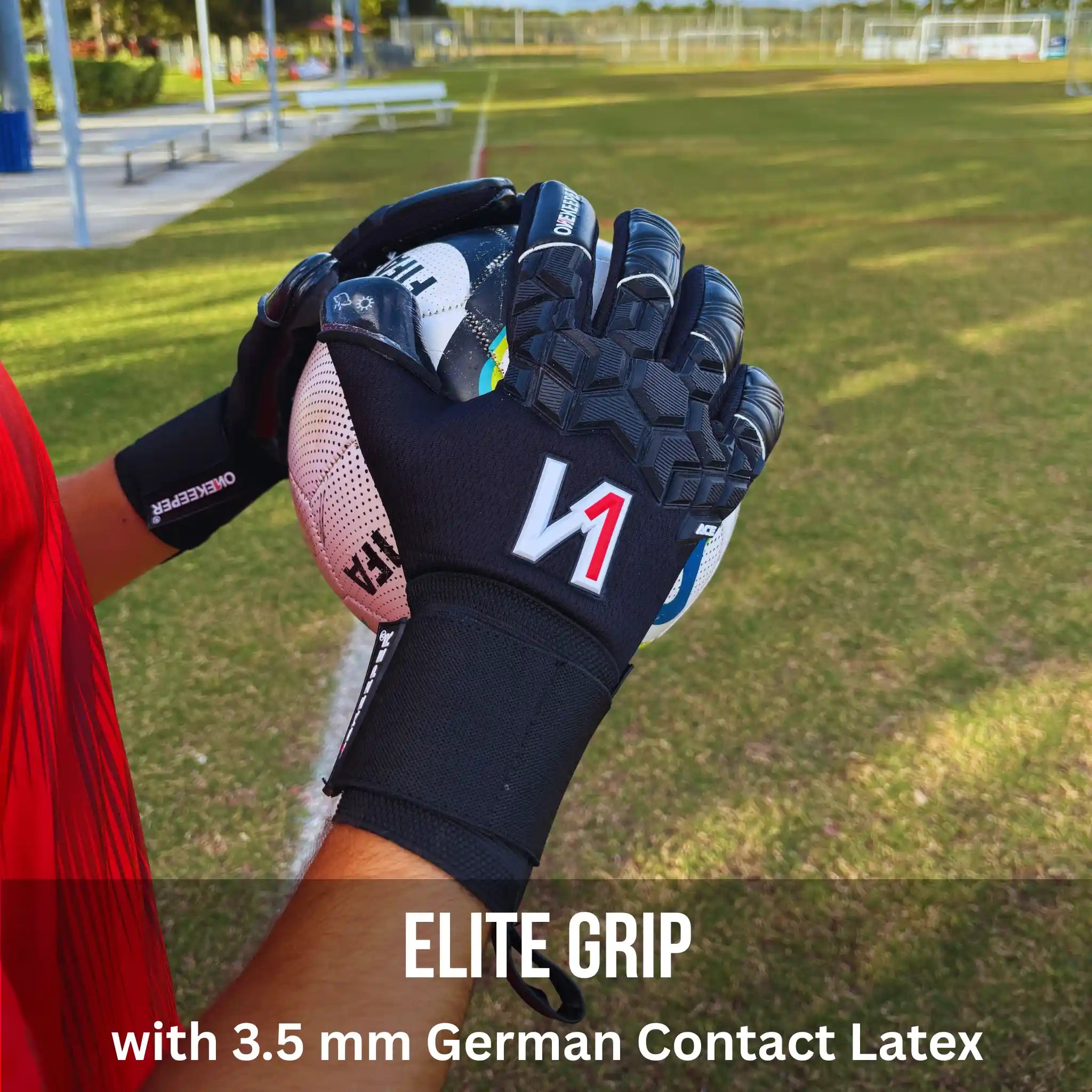 ONEKEEPER ACE Black goalkeeper glove with red and white logo held by a person on a grassy field.