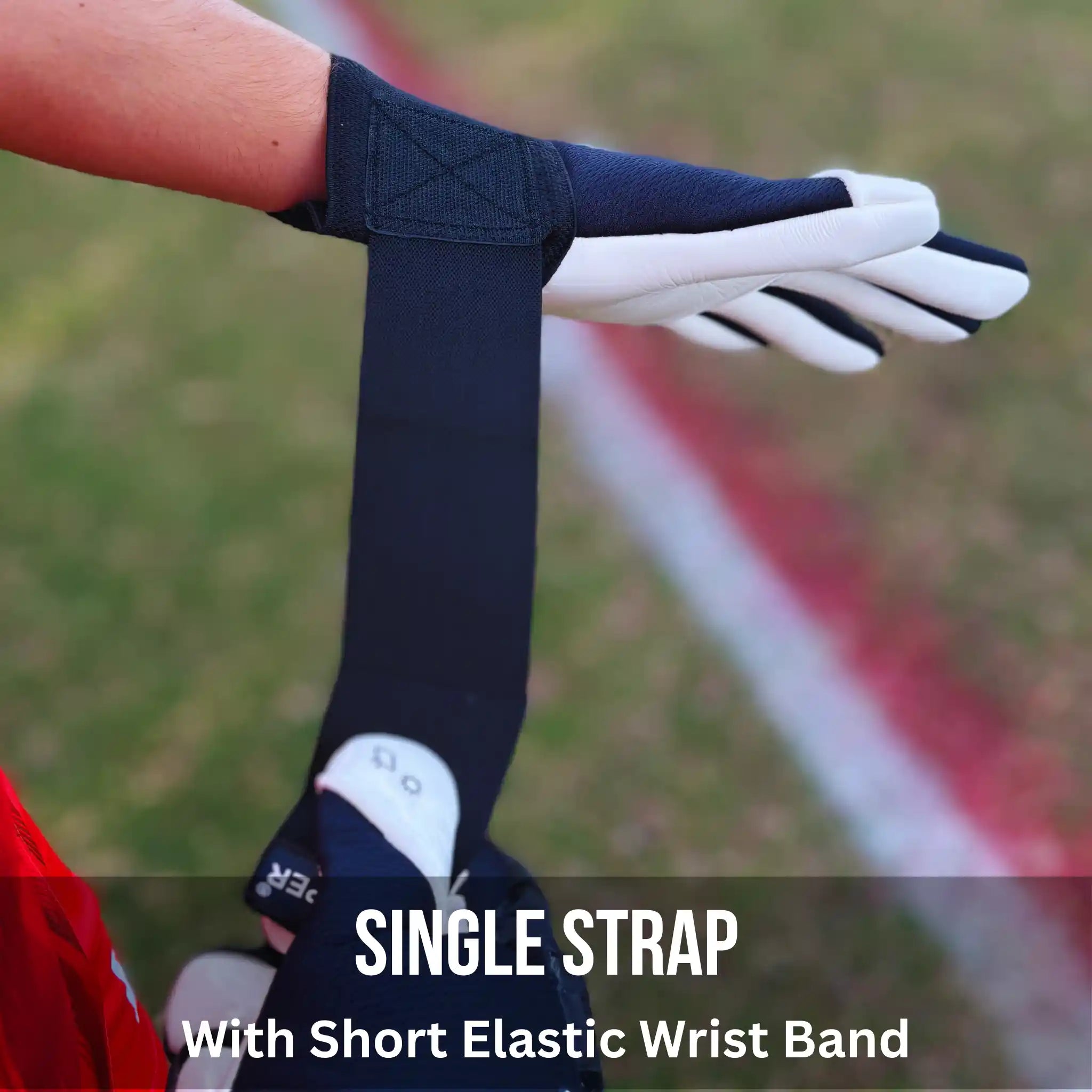 Person wearing a ONEKEEPER ACE Black and White with a short elastic wrist band on a sports field.
