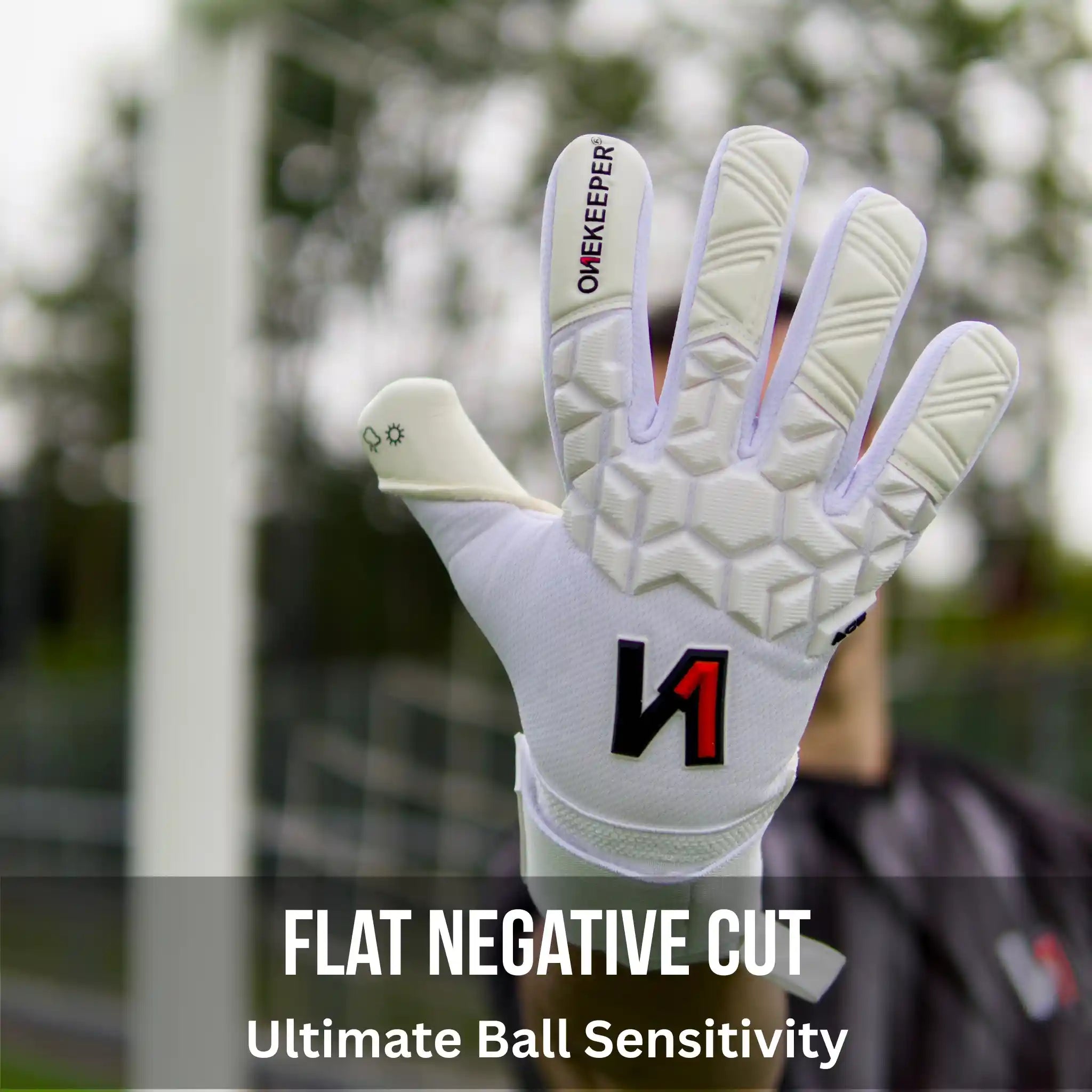 ONEKEEPER ACE White goalkeeper glove with black and red logo held by a person, blurred background