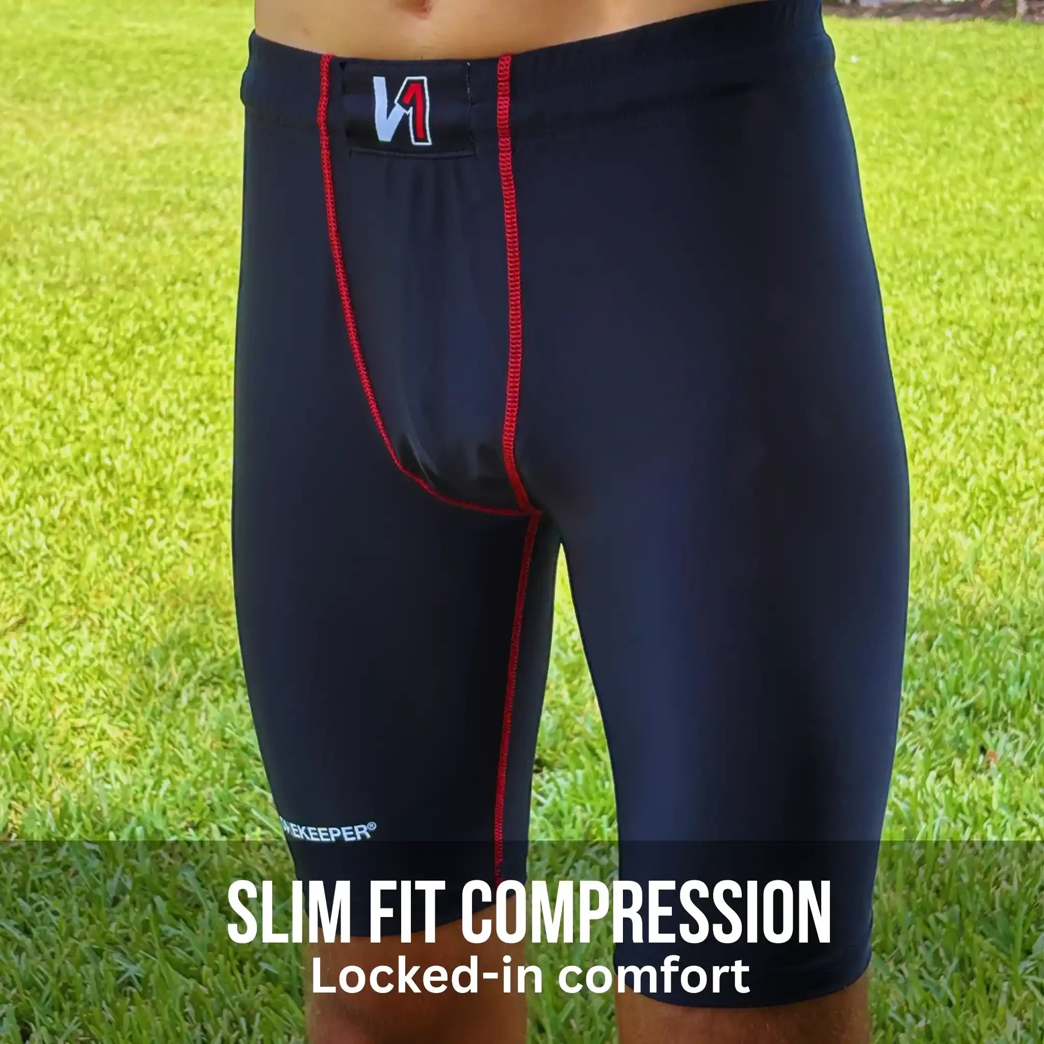 Black compression shorts with red accents on a grass background