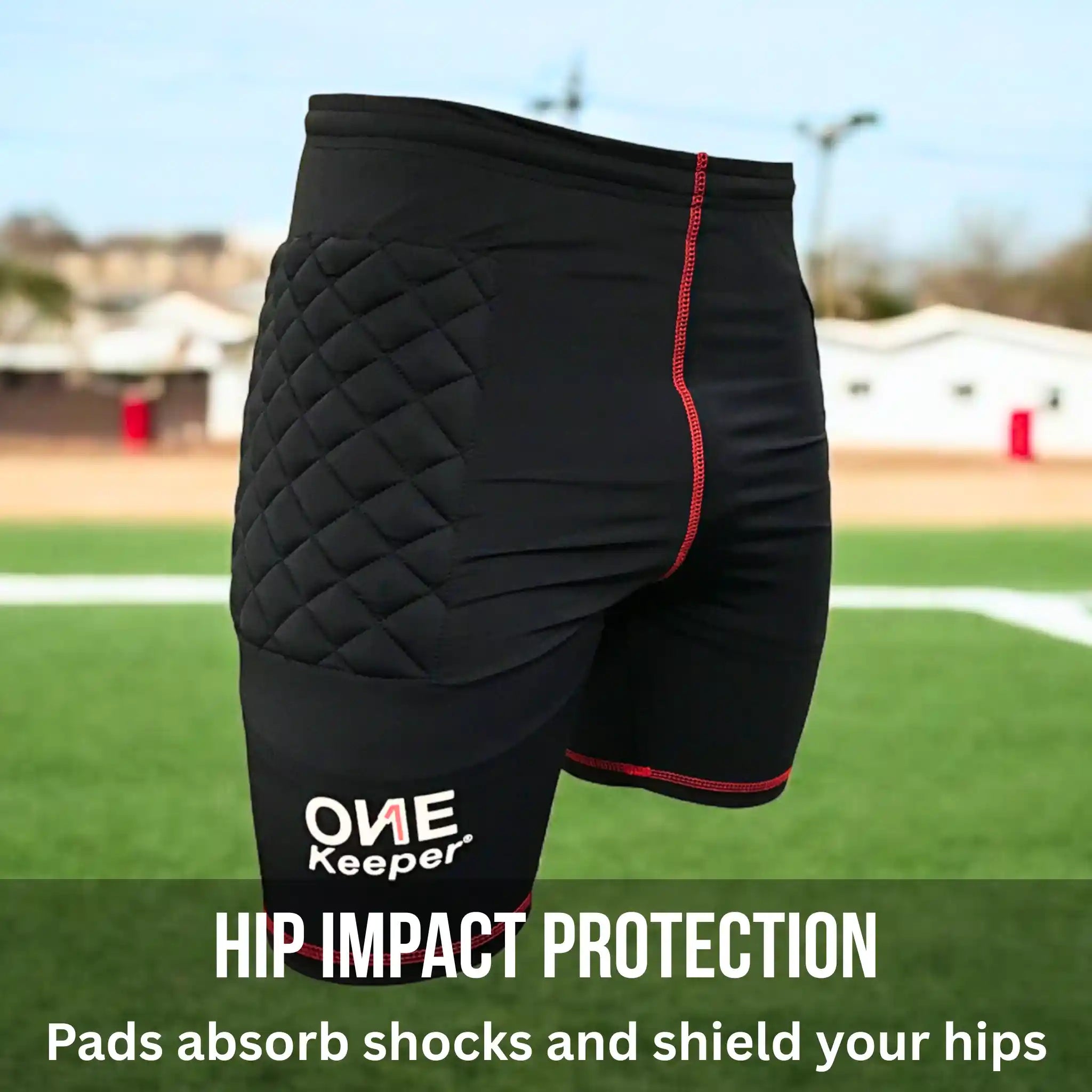 Black compression-padded shorts with quilted design and red accents on a sports field background, featuring 'ONE Keeper' branding.