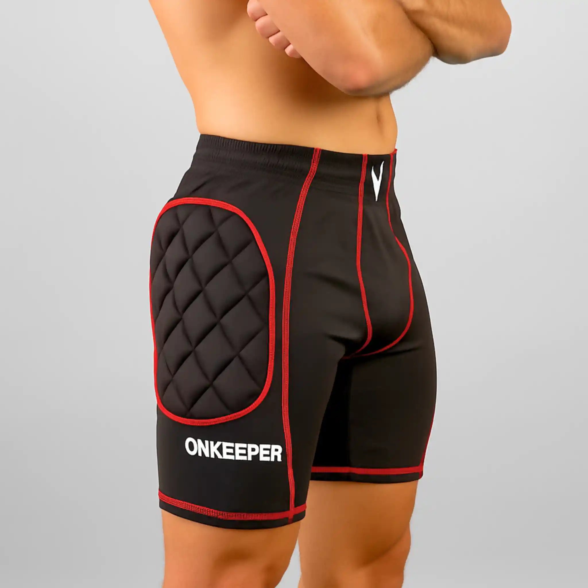 Black compression-short padded with red accents and quilted design on a gray background, featuring the brand 'ONKEEPER'.