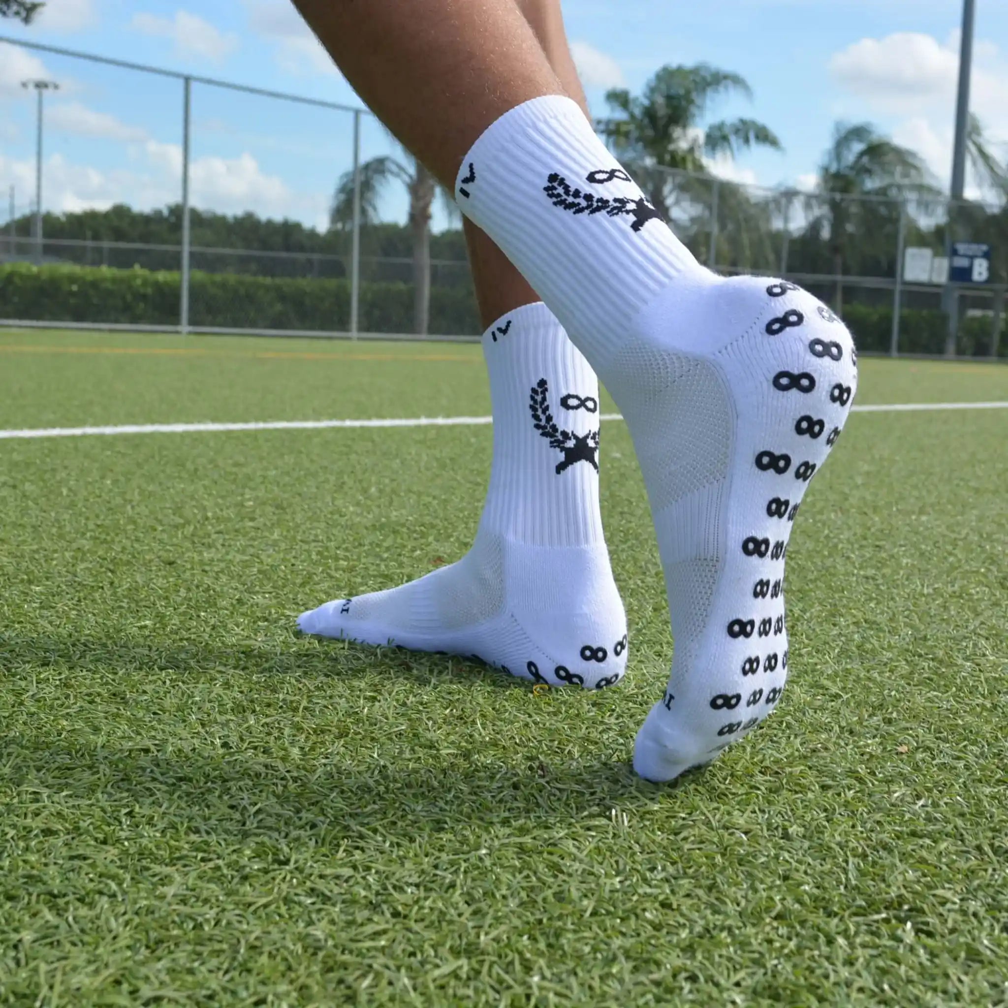 White grip socks with black patterns on a grassy field