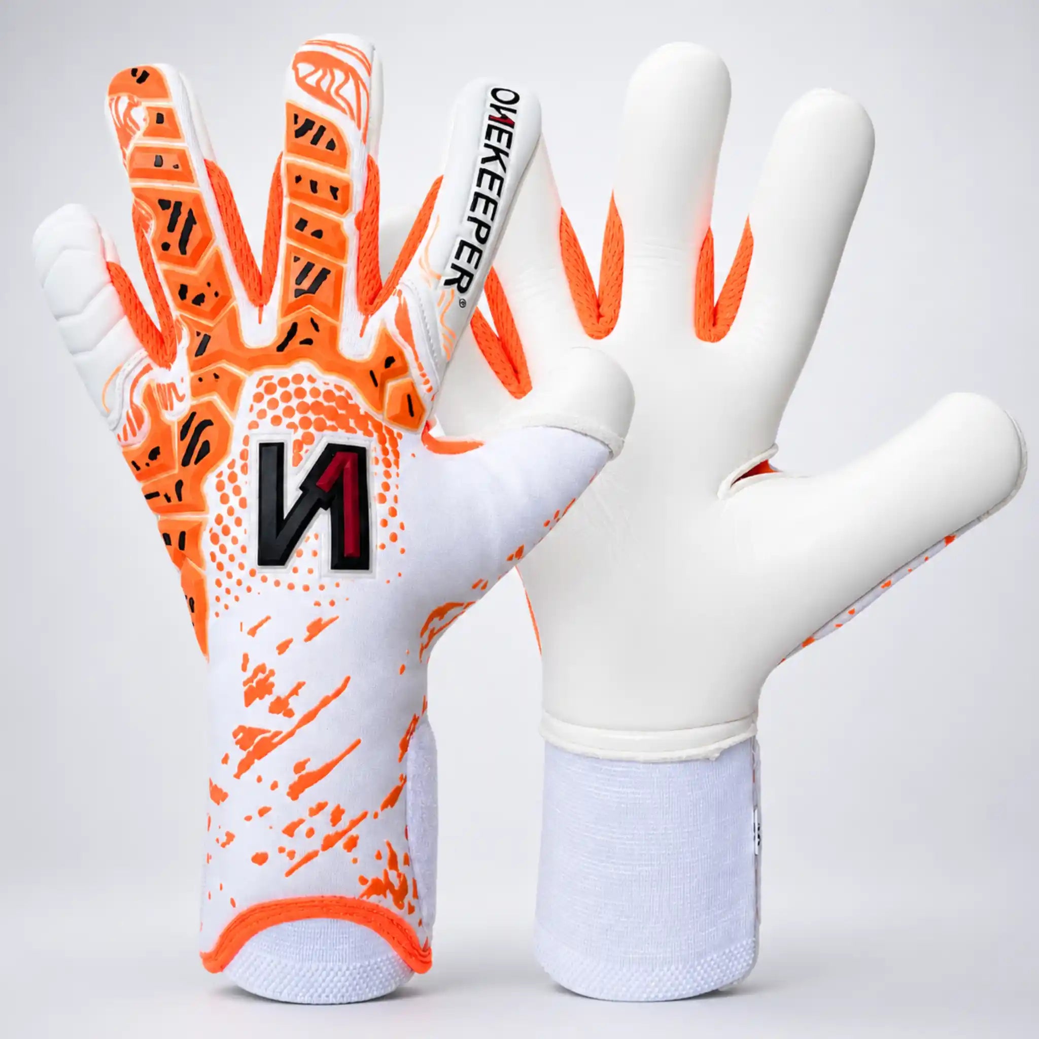 Pair of ONEKEEPER Iconic white and orange goalkeeper gloves with visible branding on a light gray background