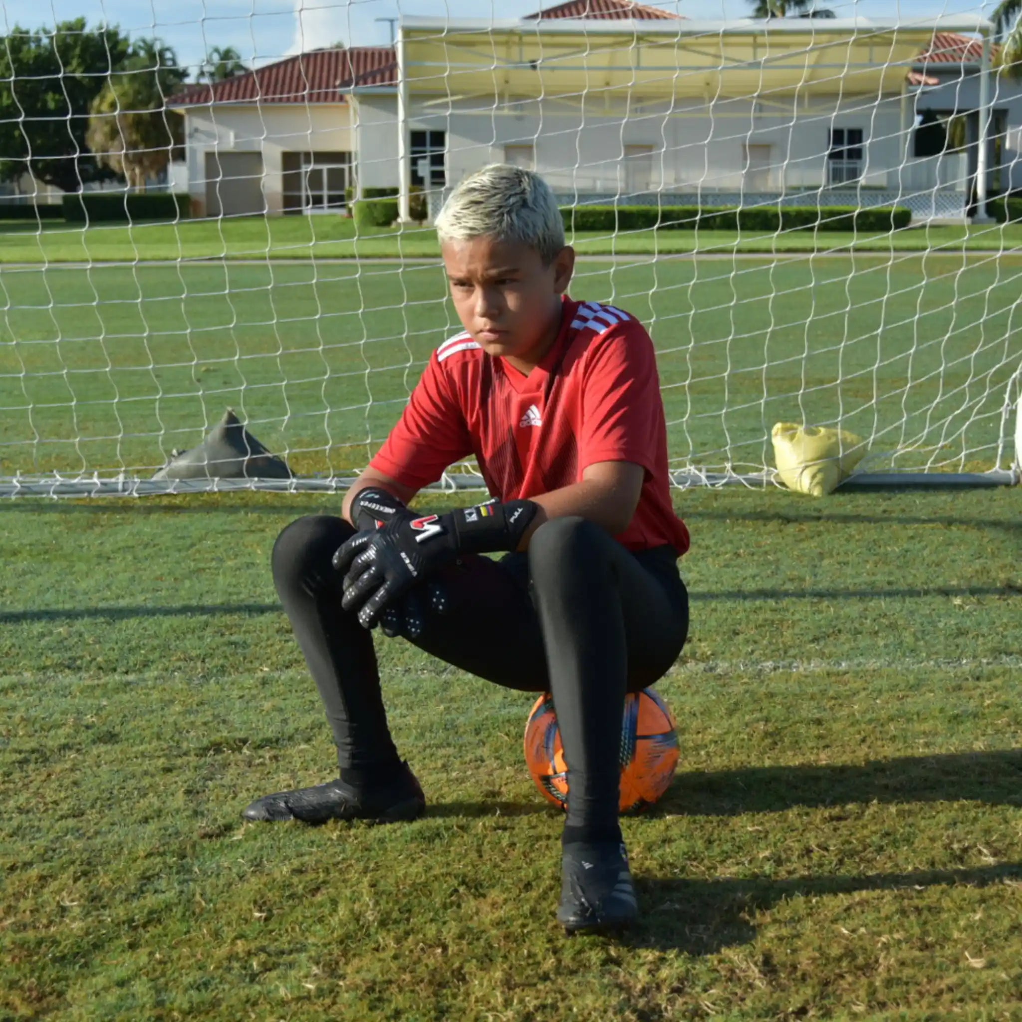 Person in red soccer jersey and a onekeeper black compression leggings.