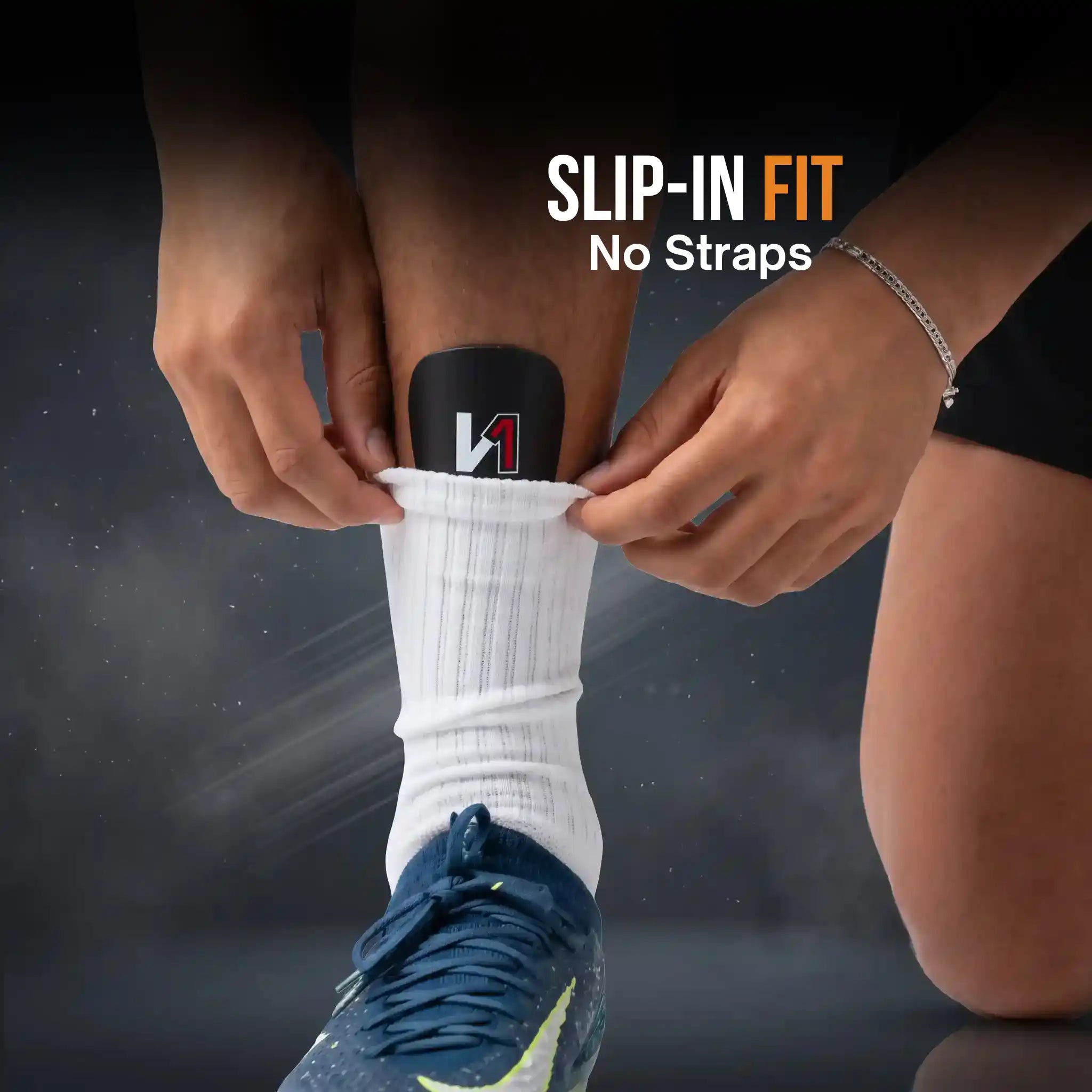 A person wearing a white ribbed athletic sock with a onekeeper mini shin guards, shown being slipped on with hands adjusting the top. The text 'SLIP-IN FIT No Straps' appears on the image.