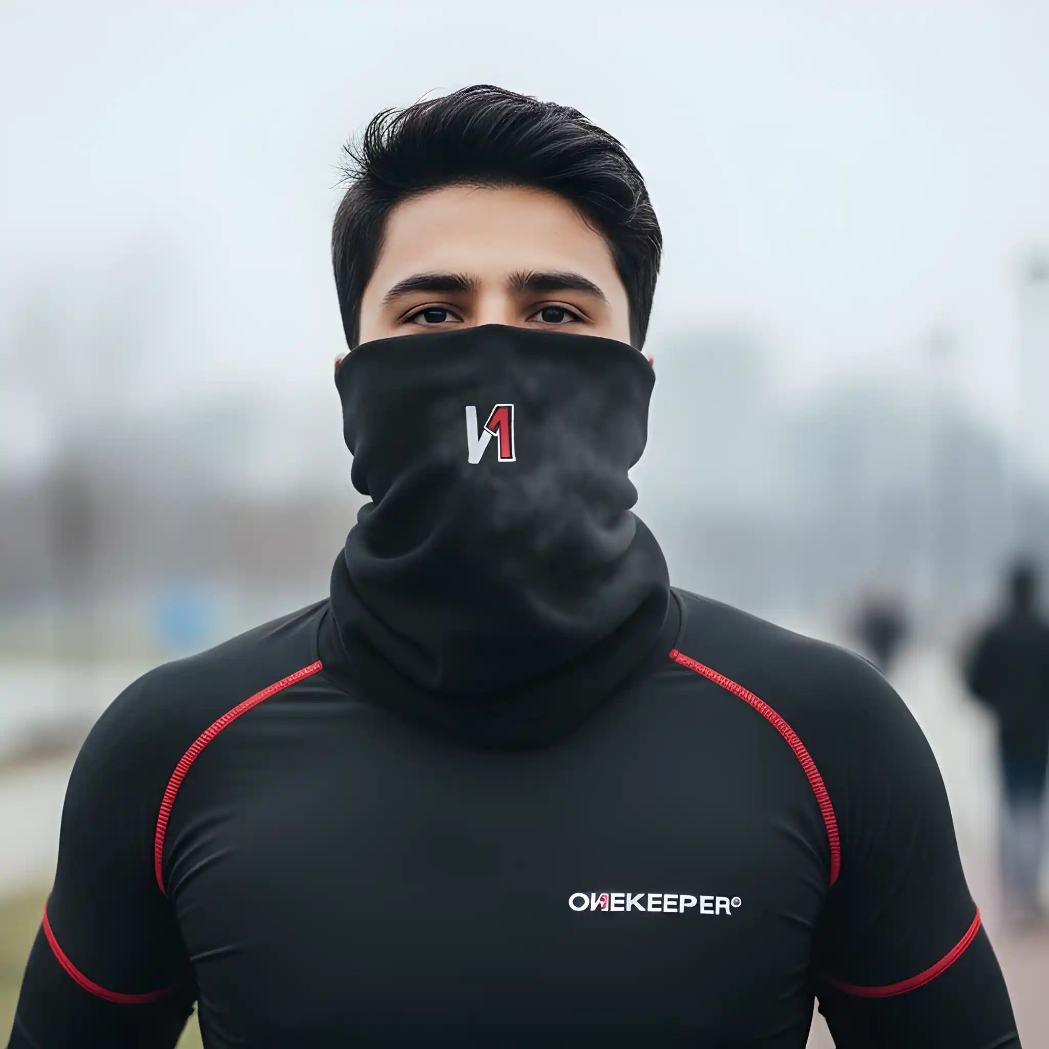 Person wearing a ONEKEEPER black sports outfit with a brand logo, standing outdoors.