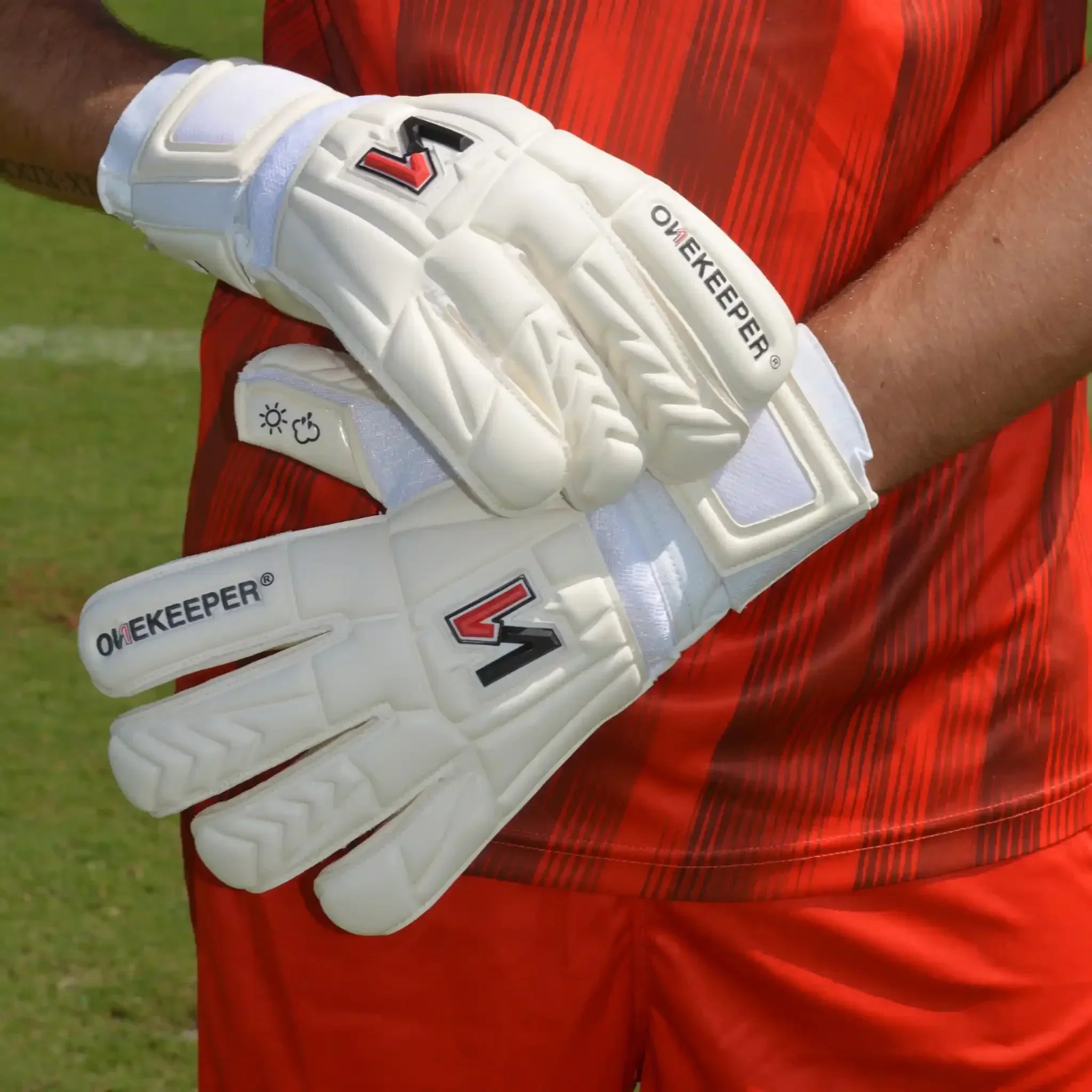ONEKEEPER USA white goalkeeper gloves worn by player in red jersey on soccer field