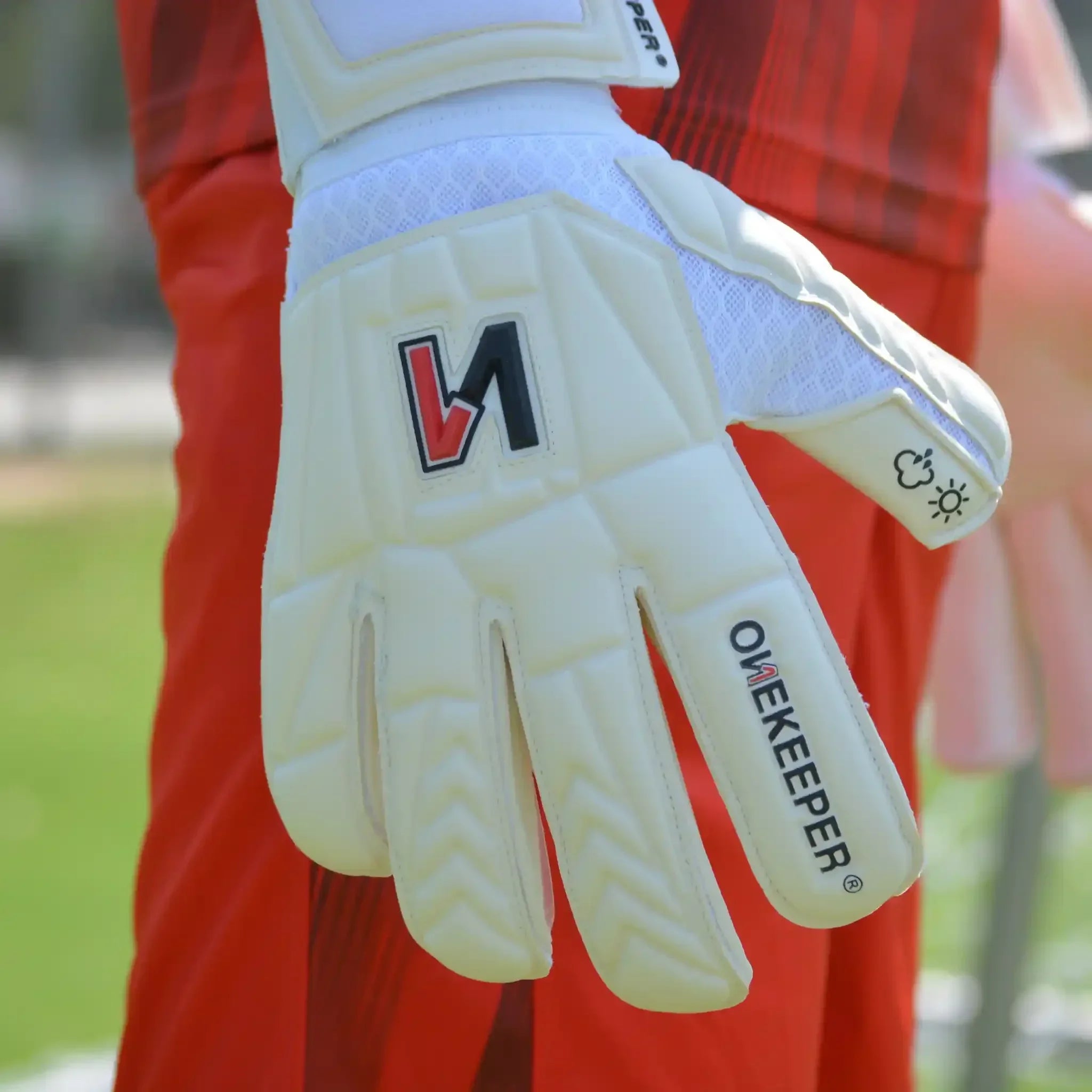 ONEKEEPER USA premium white goalkeeper glove with logo, worn outdoors on soccer field