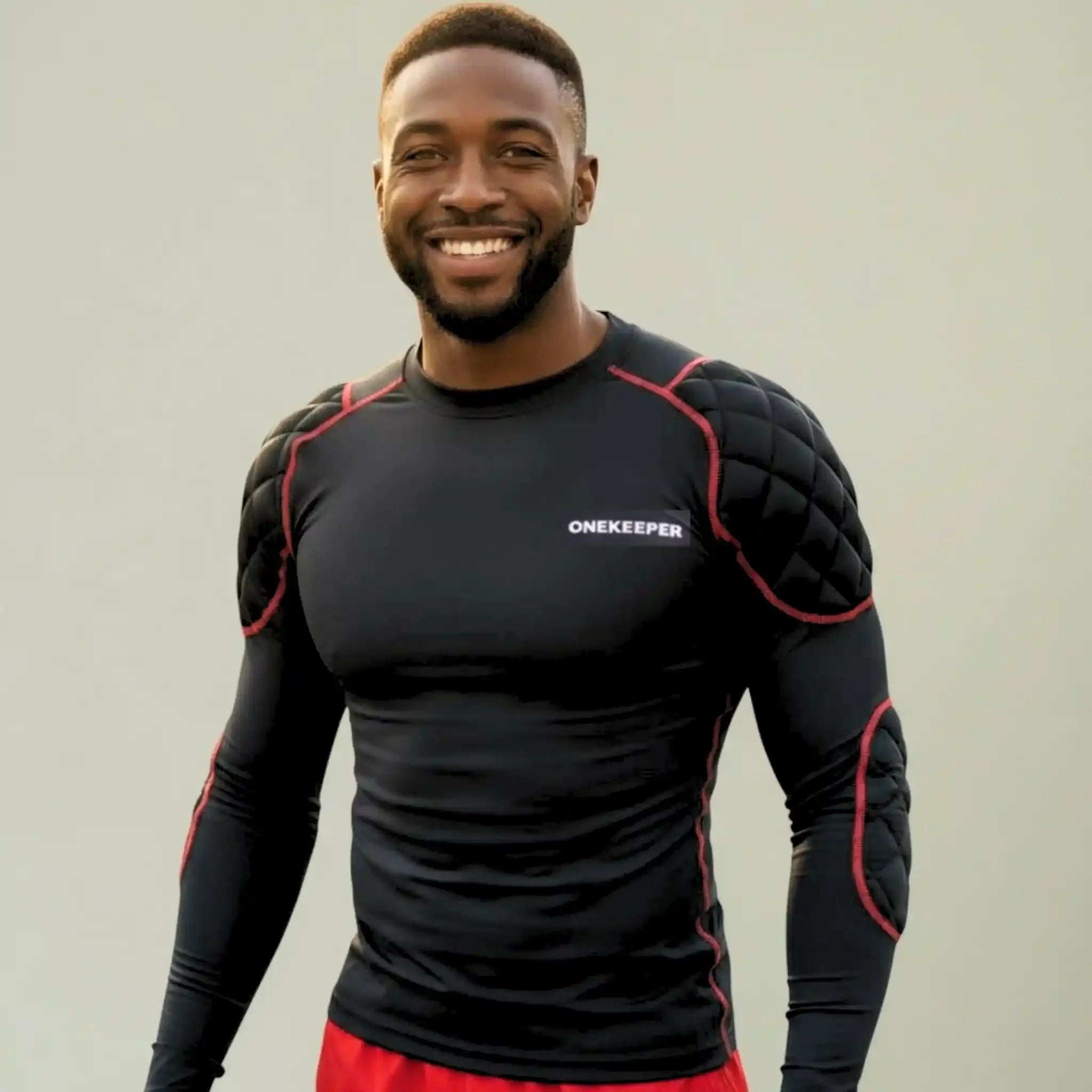 Man wearing a ONEKEEPER black padded shirt with 'ONEKEEPER' branding on a plain background
