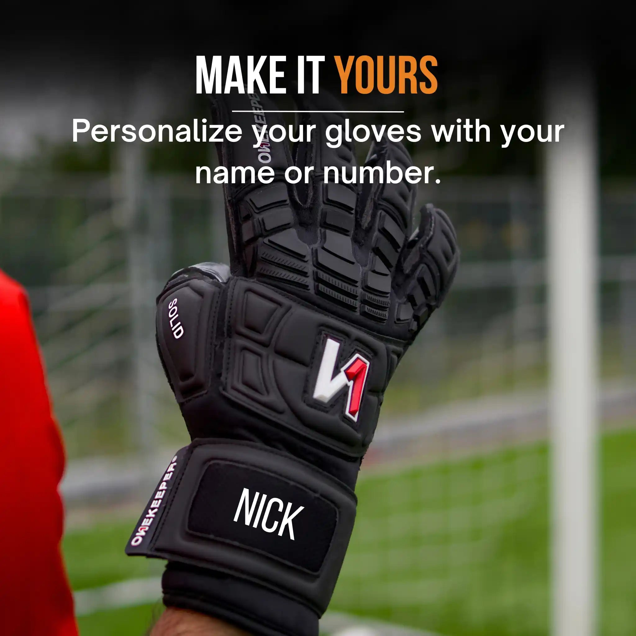 A onekeeper solid Black goalkeeper glove with 'NICK' on a blurred sports field background