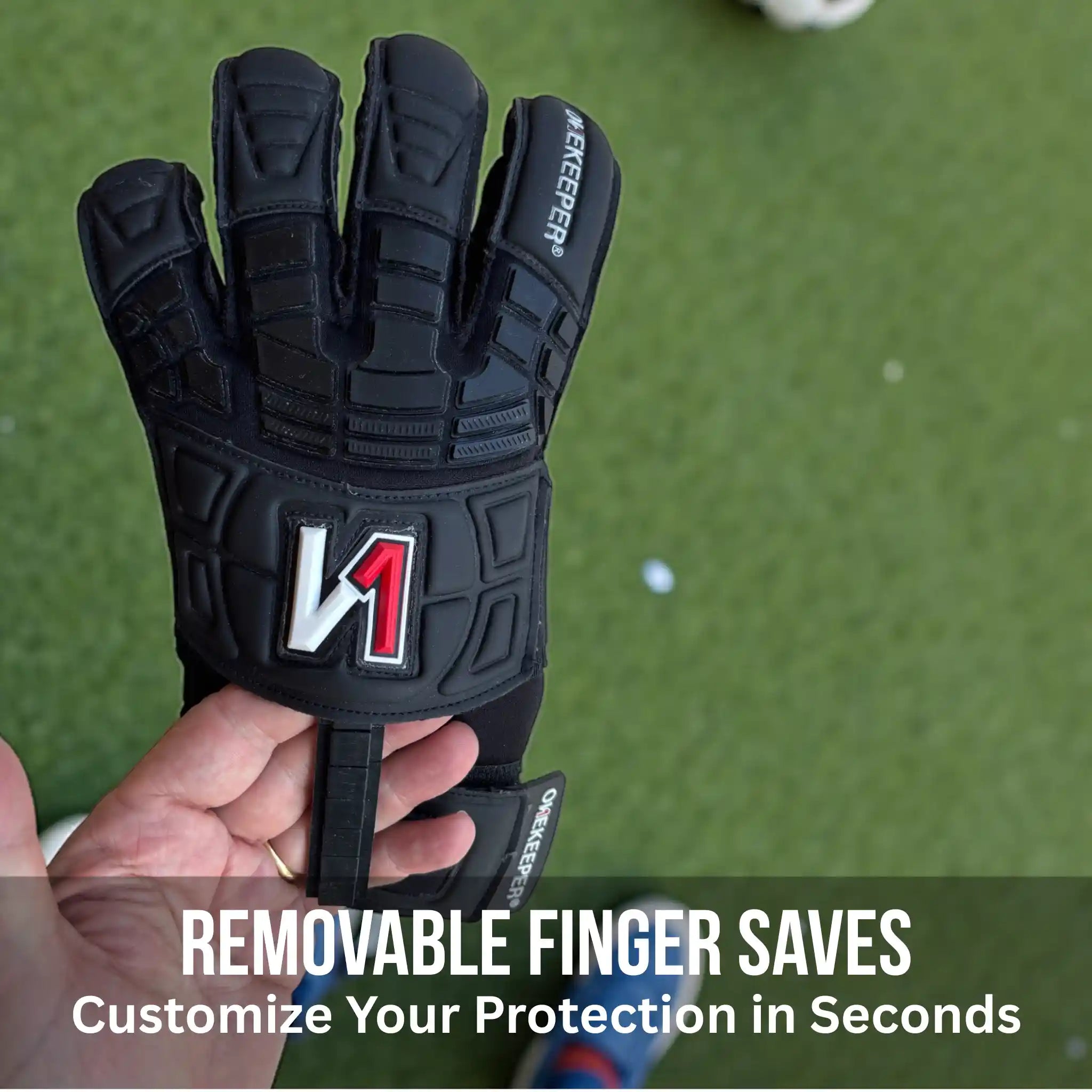 onekeeper solid Black glove with a visible brand logo held in a hand on a green background