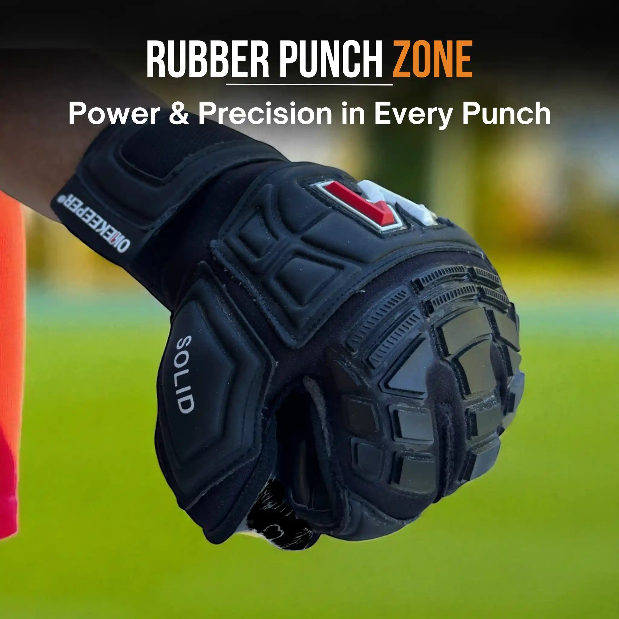 a onekeeper solid black Black  glove with 'Rubber Punch Zone' branding on a blurred sports field background.
