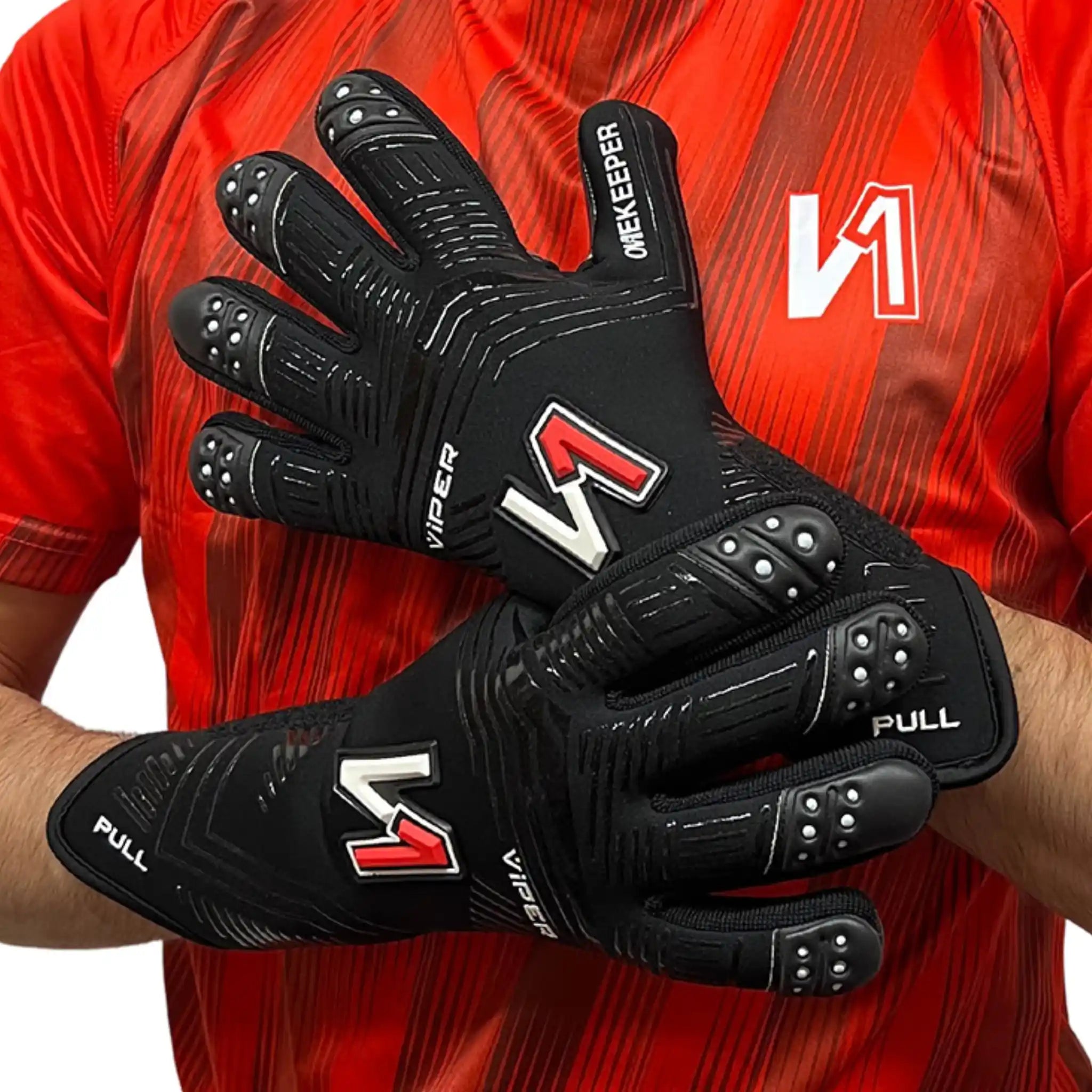 onekeeper viper Black goalkeeper gloves with red and white logo worn by a person in a red sports jersey.