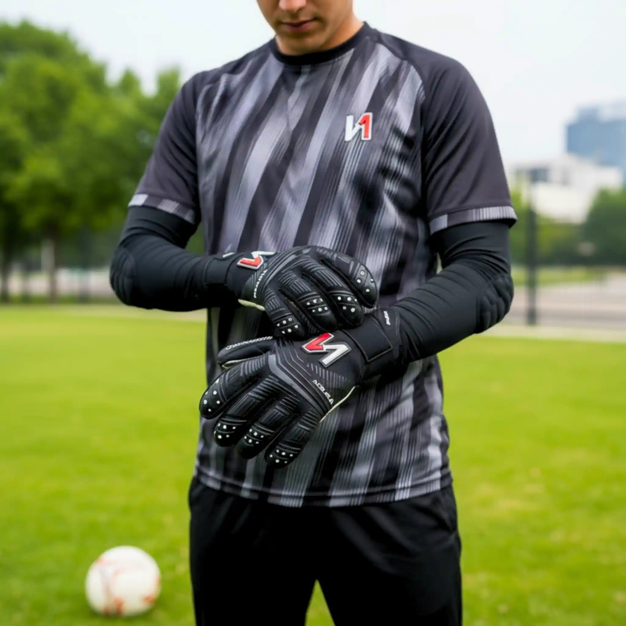 Person wearing sports attire and onekeeper viper black gloves on a grassy field