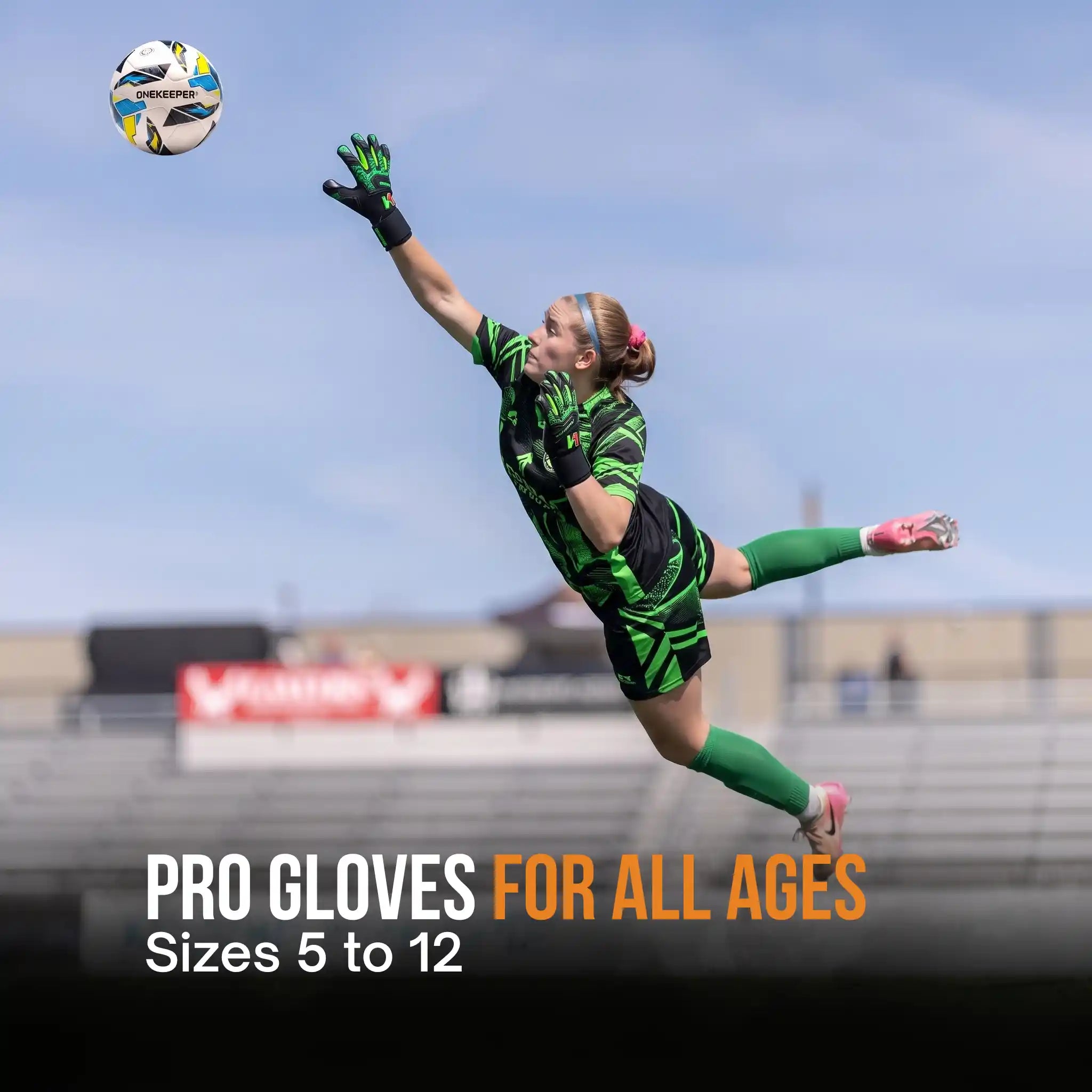 A soccer goalkeeper in a green and black uniform dives to catch a ball witha onekeeper legacy black gloves, set against a stadium background with text overlay reading 'PRO GLOVES FOR ALL AGES Sizes 5 to 12'.
