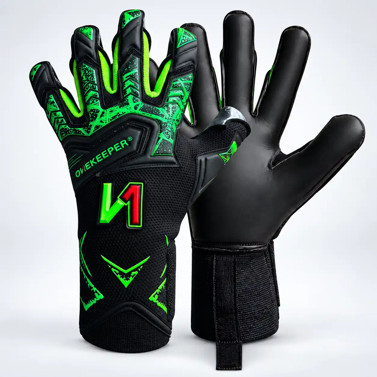 A pair of Onekeeper Legacy black and green goalkeeper gloves with vibrant neon green accents and patterns, displayed against a clean white studio background. One glove is shown from the back with the wrist strap fastened, and the other is turned to show the palm side with the brand name 'OH-KEEPER' and a large stylized 'M' logo.