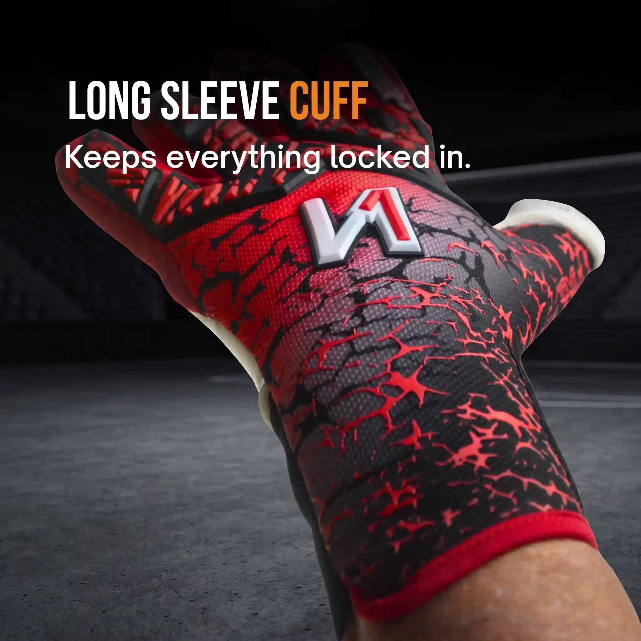 A close-up of a onekeeper mana red goalkeeper glove with a red and black textured pattern, featuring a white and red 'M' logo on the back of the cuff. White text at the top reads 'LONG SLEEVE CUFF Keeps everything locked in.