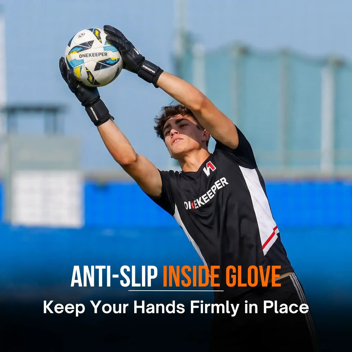 Youth goalkeeper wearing a onekeeper solid black anti-slip gloves catching soccer ball on field, designed for secure fit and grip